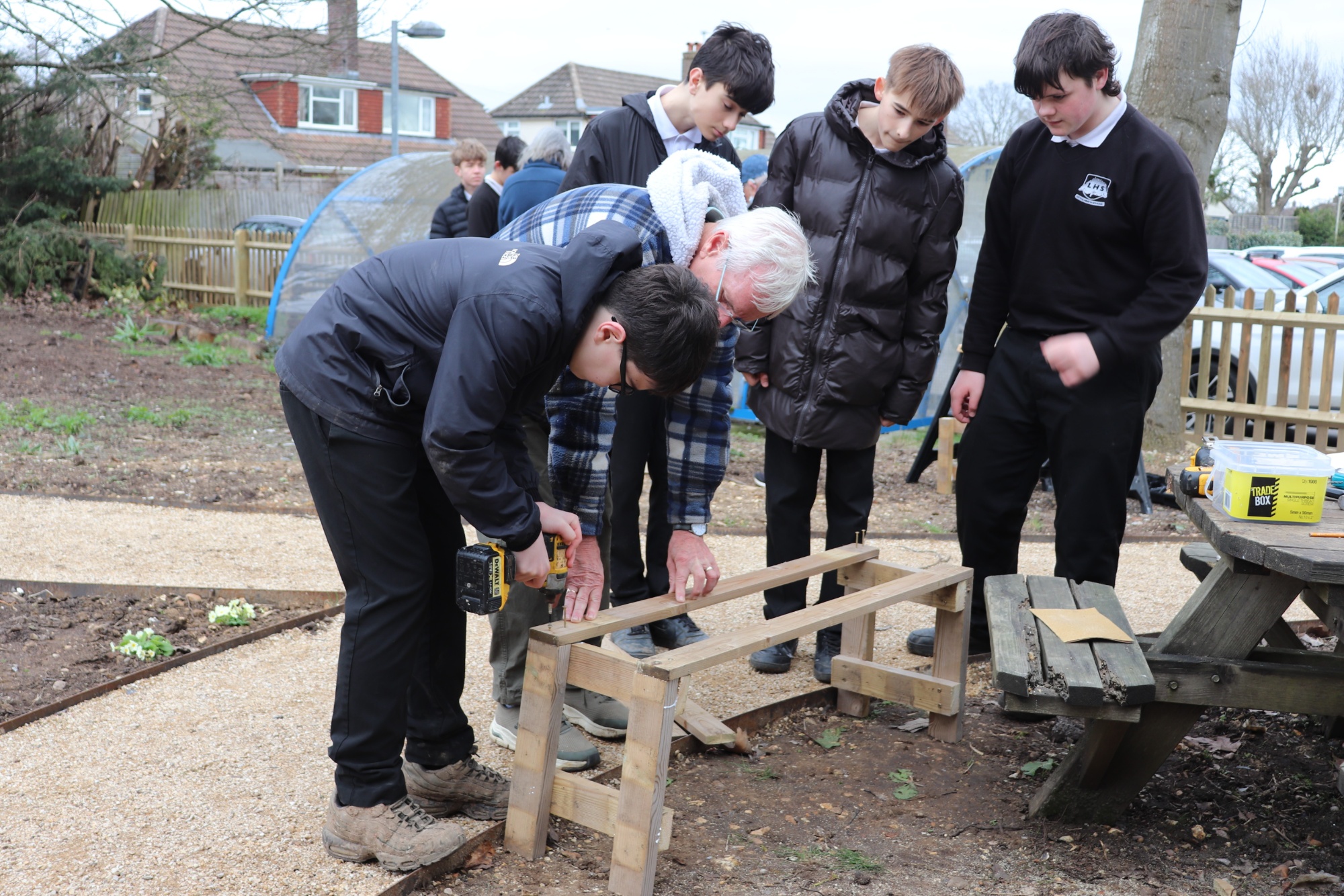 Y9 Tech students work on bench seating with PSG volunteers
